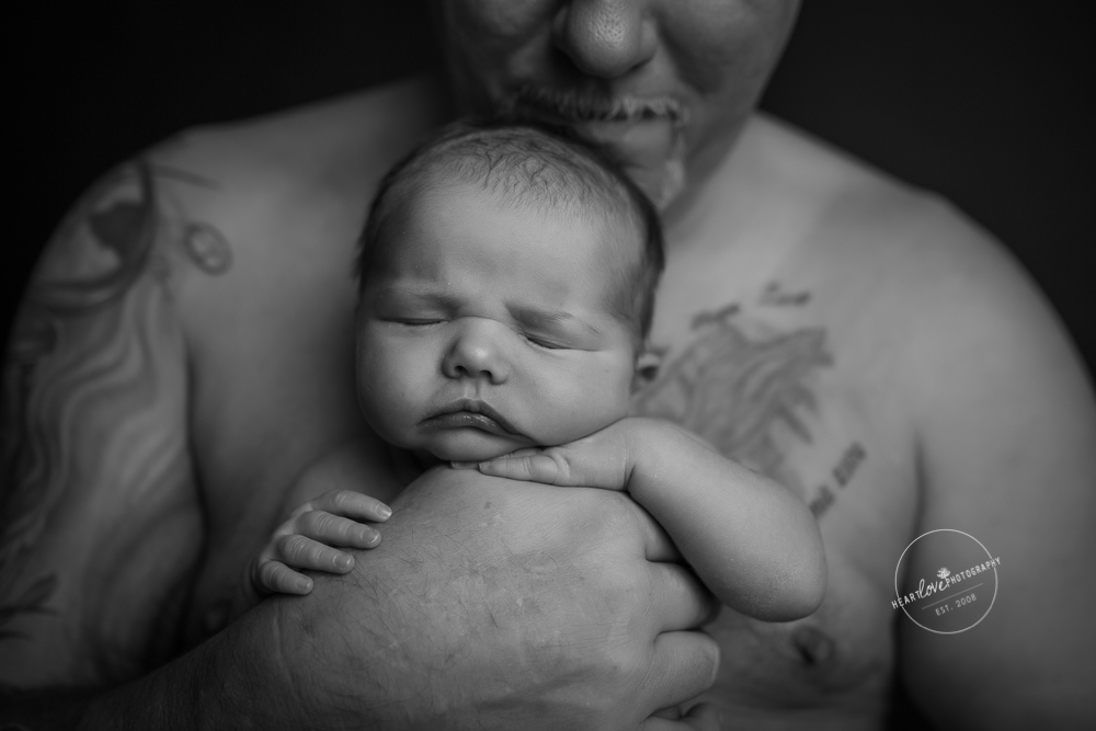 dad with tattoos holding newborn skin-to-skin