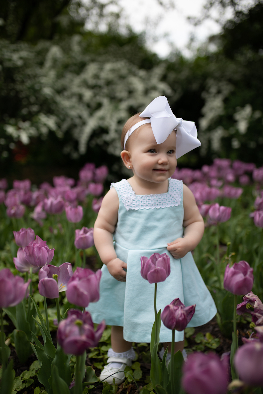 baby standing in tulip field