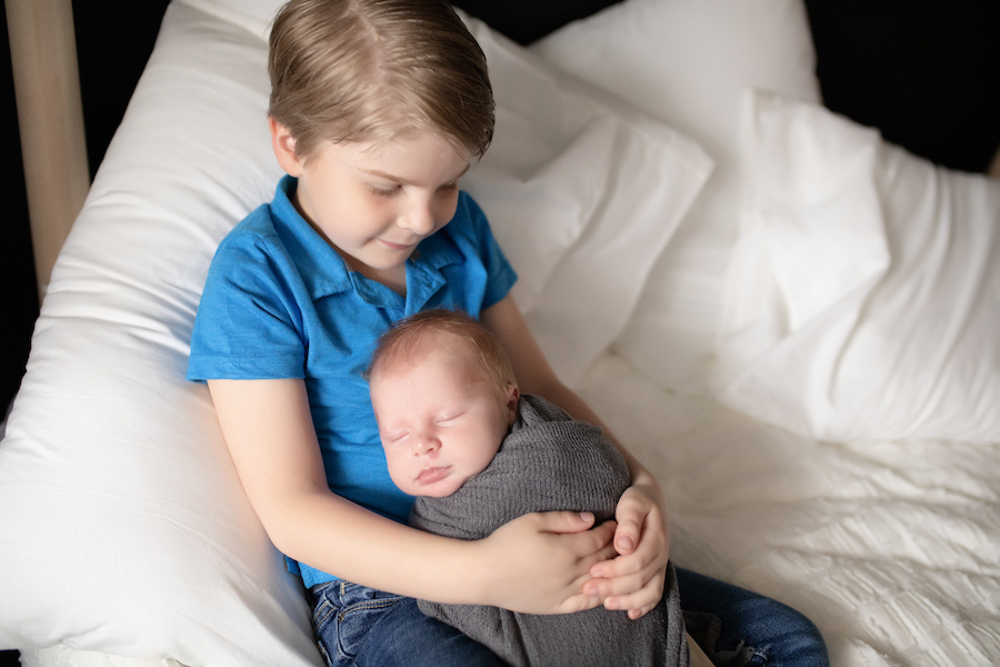 Older brother holding baby