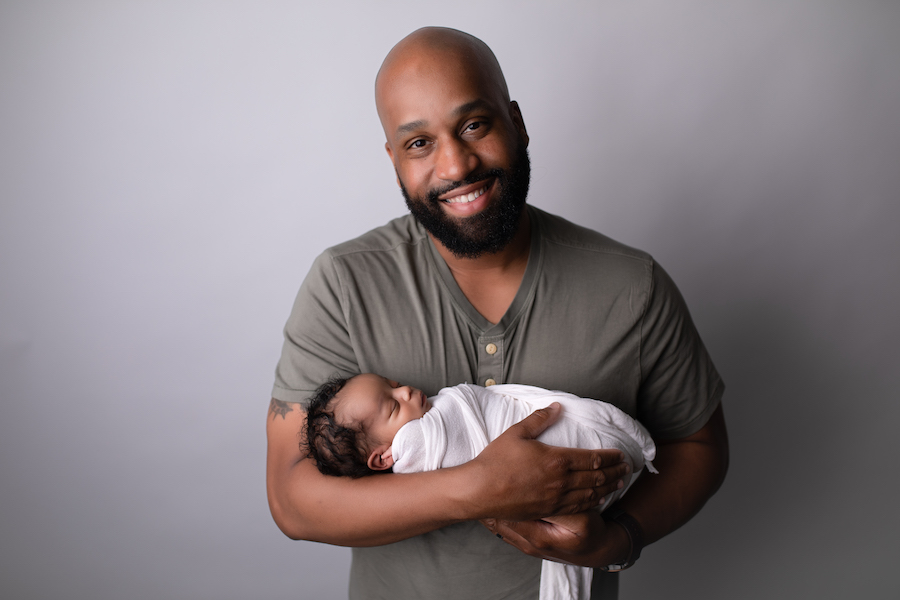 Dad smiling holding newborn