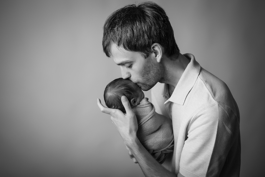 Dad kissing baby's forehead