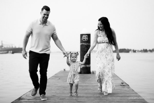 mom, dad and toddler walking on boat ramp at canton waterfront baltimore